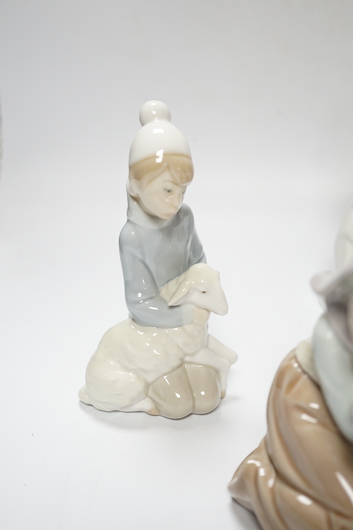 Five Lladro figures; two angelic, two nativity, one of a sleeping child and another of a girl with a lamb, all in boxed, largest 17cm high